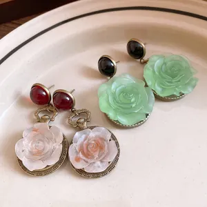 Detailed macro shot of vintage resin rose flower drop earrings with elegant antique finish