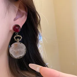 Vintage bronze drop earrings featuring a dark red stud and carved resin flower pendant