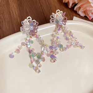 Close-up of dopamine style flower earrings with iridescent sequin tassels