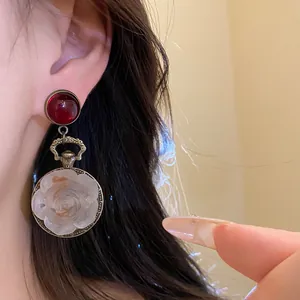 Vintage-style resin rose flower pendant earrings shown in a close-up detail shot