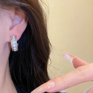 Primo piano di orecchini a cerchio in argento decorati con brillanti strass di cristallo