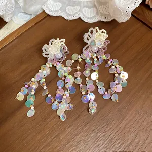 Close-up of vibrant dopamine style flower tassel earrings with iridescent sequins