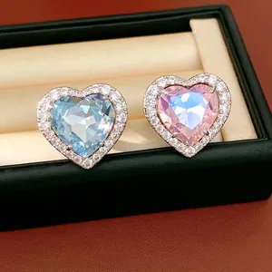 Exquisite close-up of blue and pink heart-shaped crystal rings with sparkling CZ halo setting