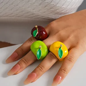 Detailed macro view of colorful oil-drip apple rings with metallic leaf accents.