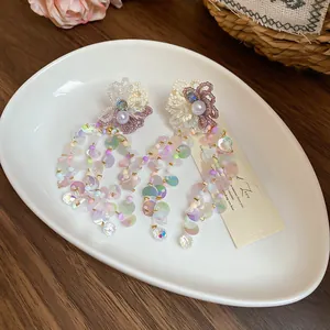 Detailed macro view of colorful floral beaded tassel earrings with pastel iridescent sequins