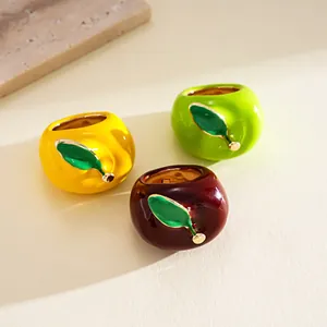 Detailed macro view of colorful enamel apple-shaped fashion rings in three vibrant colors