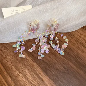 Detailed macro view of dopamine style flower tassel earrings with iridescent sequins