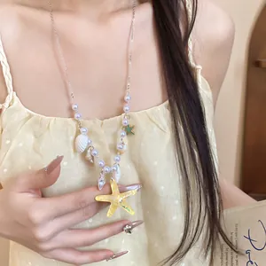 Close-up of beach starfish and shell necklace with pearls for summer vacation
