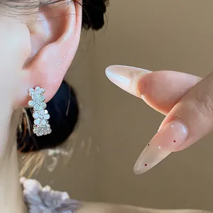 Dettaglio dell'orecchino a C a forma di fiore in argento con zirconi e smalto
