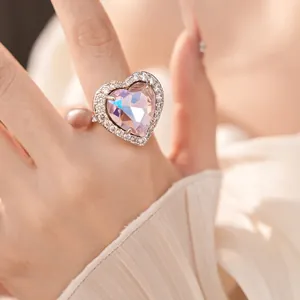 Detailed macro view of an elegant pink heart-shaped zircon ring worn on a finger