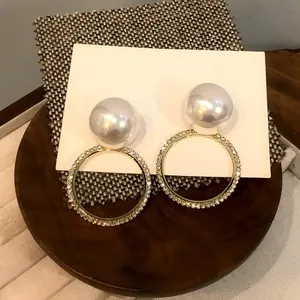 Pendientes vintage de oro con grandes perlas blancas y detalles de cristales finos