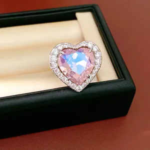 Close-up detail of a heart-shaped ring with iridescent pink stone and sparkling zircon halo