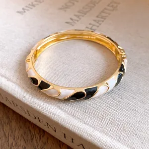 Close-up detail of a vintage bicolor enamel bangle with elegant gold finish and clasp
