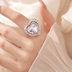 Close-up of a heart-shaped zircon ring featuring a sparkling crystal halo on a finger.