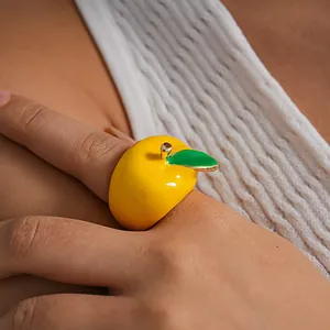 Detailed macro view showing the vibrant yellow enamel finish of this creative apple-shaped ring