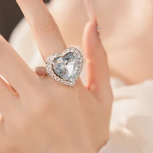 Close-up detail of a large heart-shaped light blue zircon ring with halo setting.