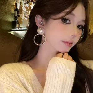 Primer plano de pendientes de aro con perlas y cristales para un look elegante.