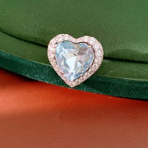 Macro view of a light blue heart-shaped zircon ring with shimmering rose gold plating.