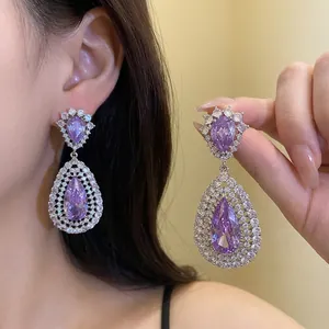 Elegant silver needle drop earrings featuring brilliant purple zircon and crystal halo