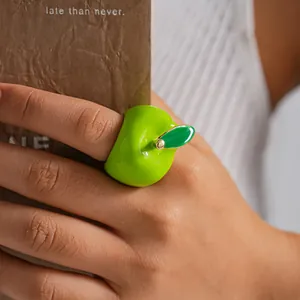 Close-up detail of a creative green apple enamel ring for women worn on the index finger