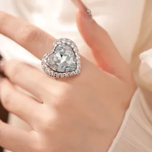 Detailed macro view of an elegant heart-shaped ring with light blue stone and pave halo.