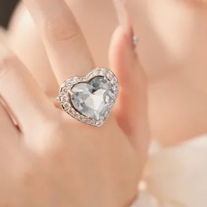 Close-up of a heart-shaped zircon ring with light blue center stone and pave accents.