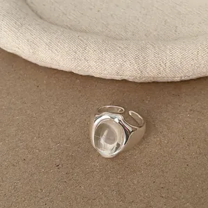 Detailansicht eines minimalistischen silbernen offenen Rings mit klarem Edelsteinbesatz