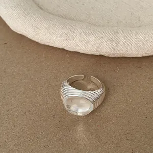 Detailansicht eines silberfarbenen gerippten Rings mit einem großen klaren Stein