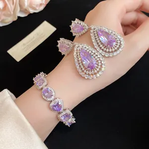 Close-up detail of luxury teardrop zircon earrings and matching bracelet set in purple