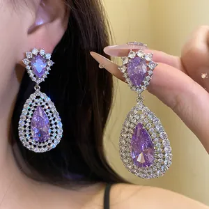 Detailed close-up of luxurious purple teardrop zircon earrings with silver plating
