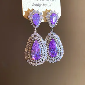 Detail of purple water drop zircon earrings with crystal accents on jewelry card