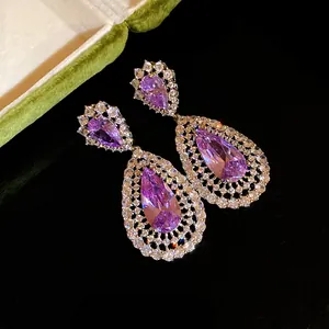 Detail of purple pear-shaped zircon earrings with crystal-studded hollow design