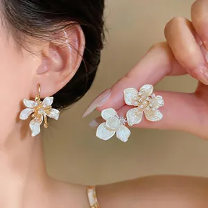 Exquisite detail of French irregular camellia earrings with pearls and micro-pave zircons