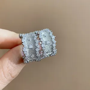 Close-up view of textured C-shaped stud earrings with pave cubic zirconia stones.