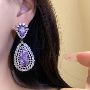 Elegant purple pear-cut zircon hollow drop earrings worn by a model for detail view.