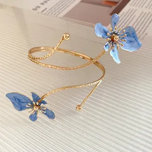 Bracelet de bras spirale doré élégant avec deux accents de fleurs en émail bleu chic