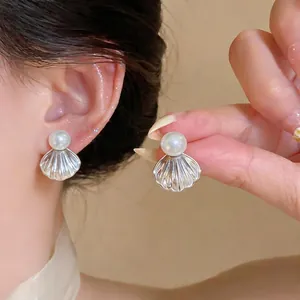 Élégantes boucles d'oreilles en argent avec perles portées par un mannequin pour un style