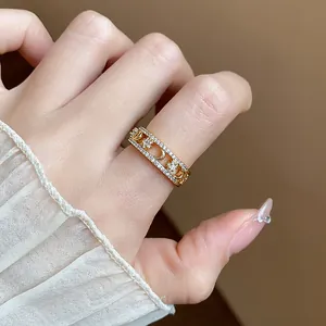 Close-up view of a gold-plated ring featuring zircon star and moon designs on a finger.