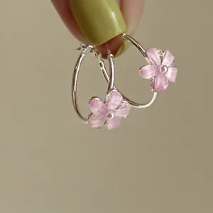 Vista dettagliata di orecchini a cerchio con fiori rosa e ago in argento e perla