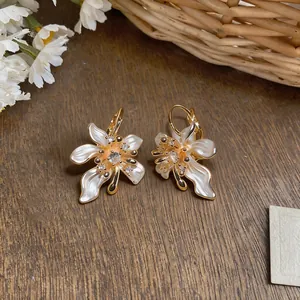 Detailed view of French irregular camellia earrings with sparkling zircon accents