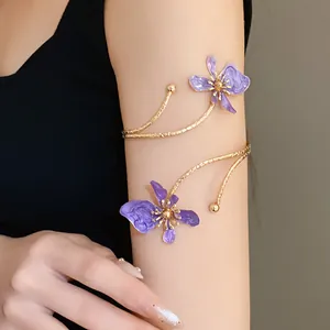Vue détaillée de l'élégante fleur en émail violet et de la finition dorée du haut du bras.