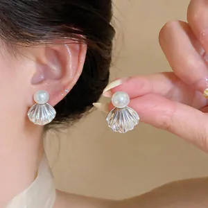 Vue détaillée de boucles d'oreilles perles françaises avec un design de coquillage élégant