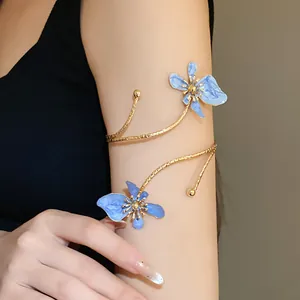 Vue détaillée d'un élégant bracelet de bras doré avec des fleurs en émail bleu