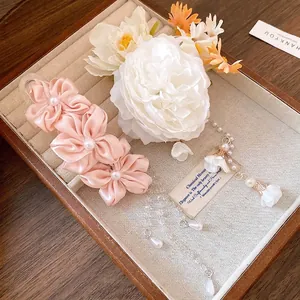 Elegant pink fabric flower hair clip with pearl tassels in jewelry box