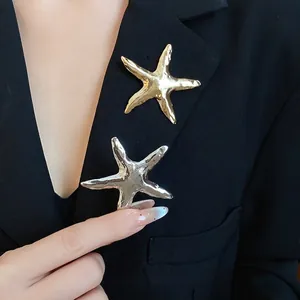 Vintage-Seestern-Broschen mit Faltenstruktur in Gold und Silber auf einem Blazer