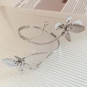 Gros plan détaillé d'un bracelet de bras spirale en métal argenté avec motifs floraux.