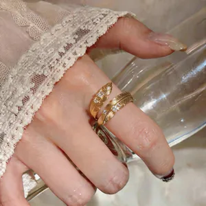 Primo piano elegante di un anello a piuma placcato oro 18K con zirconi bianchi brillanti