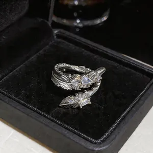 Macro di un anello a piuma color argento con pietre di zircone in una scatola da regalo