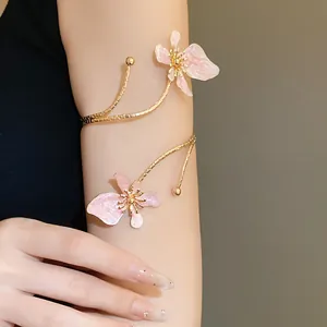 Détail d'un élégant bracelet de bras à fleurs en émail rose porté sur le bras d'un mannequin