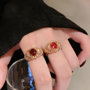 Dettaglio degli anelli a piuma in zircone placcati oro 18K con eleganti pietre rosse centrali